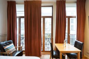 a dining room with a table and chairs and windows at Because the Night city lodge in Antwerp