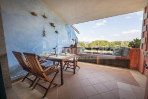 een eetkamer met een tafel en stoelen op een balkon bij 23 BAIA FARO - Trilocale mansardato con ampia terrazza vista mare in Palau