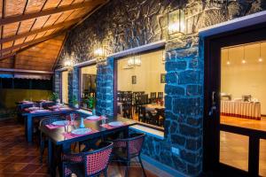 a restaurant with tables and chairs and a stone wall at Vaikundam Legacy in Kaliyal