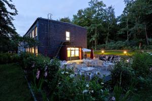 ein Haus mit Tischen und Stühlen in einem Garten in der Unterkunft Seminarhaus Europäische Akademie in Waren (Müritz)