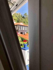 a view from a window of a house with flowers at La casina de La Fragua in Lastres