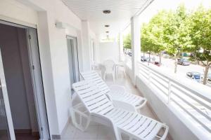 einen Balkon mit weißen Stühlen und Straßenblick in der Unterkunft COSTA DAURADA APARTAMENTS - Royal 106 Luxe in Salou