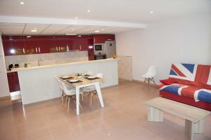ein Wohnzimmer mit einem Tisch und einer Küche in der Unterkunft COSTA DAURADA APARTAMENTS - Royal 106 Luxe in Salou