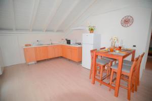 a kitchen with a table and a white refrigerator at Ca' Mari in Gravellona Toce