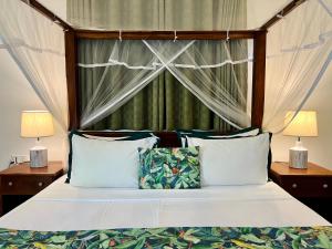 a bedroom with a canopy bed with two lamps at Green Escape Unawatuna in Unawatuna