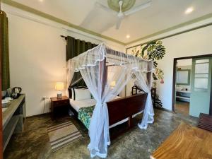 a bedroom with a bed with a canopy at Green Escape Unawatuna in Unawatuna