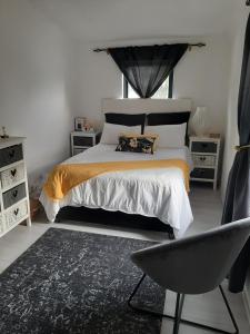 sypialnia z łóżkiem i krzesłem w obiekcie White house w Kapsztadzie