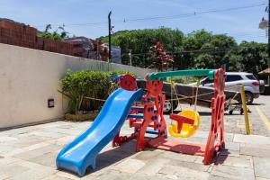 a playground with a slide in a parking lot at FLAT EM JUQUEHY COM AR COND, PISCINA e CHURRASQUEIRA in São Sebastião