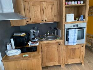 a kitchen with wooden cabinets and a sink at Le Loire-Etain in Albiez-Montrond