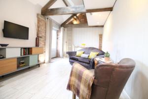 a living room with a couch and a tv at The Hayloft - Cheshire in Crewe