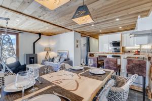 cocina y sala de estar con mesa y sillas en Les Nards, en Praz-sur-Arly