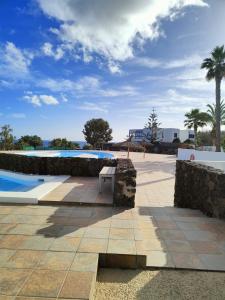 ławka siedząca przed basenem w obiekcie Ailana Suite Vistas al Mar y con Piscina w Costa Teguise