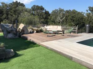 een houten terras met een bank en stoelen erop bij villa rocca in Sotta