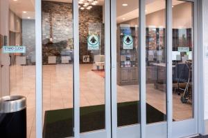 a store front with glass doors with signs on them at Holiday Inn Marquette by IHG in Marquette