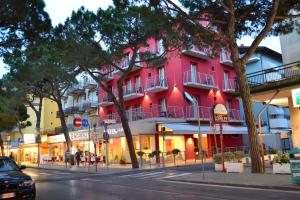 un edificio rosa al lado de una calle en Hotel Morena, en Lido di Jesolo