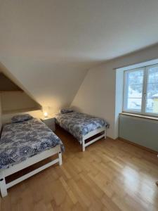 a bedroom with two beds and a large window at Wunderschöne Ferienwohnung in den Bergen in Tiefencastel