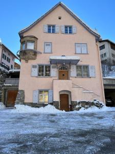 een groot huis met sneeuw ervoor bij Wunderschöne Ferienwohnung in den Bergen in Tiefencastel