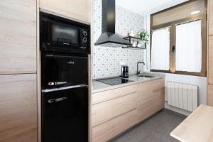 een kleine keuken met een zwarte koelkast en een wastafel bij Aresti Old Town by Bilbao Living in Bilbao