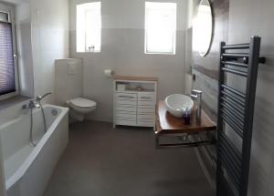 een badkamer met een bad, een toilet en een wastafel bij Haus am Seidelberg in Dürrhennersdorf