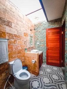 a bathroom with a toilet and a sink and a red door at Villa Danu in Kintamani