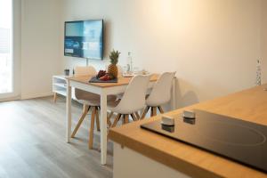 eine Küche und ein Esszimmer mit Tisch und Stühlen in der Unterkunft JayBnB - Apartment direkt am Hafen - mit UHD TV und Netflix in Dortmund