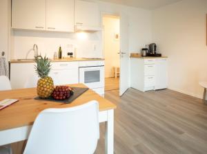 eine Küche und ein Esszimmer mit einer Ananas auf einem Tisch in der Unterkunft JayBnB - Apartment direkt am Hafen - mit UHD TV und Netflix in Dortmund + 1 Foto