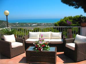 a patio with wicker chairs and a table with flowers at Residence Maresol in Vieste