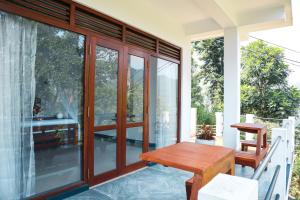 a porch with a wooden table and glass doors at Duet Hearts in Ella