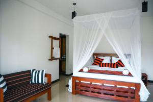 a bedroom with a canopy bed and a couch at Duet Hearts in Ella