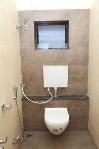 uma casa de banho com um WC e uma janela em M R Residency Belagavi em Belgaum