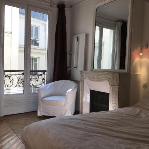 1 dormitorio con cama, espejo y silla en Plein centre, en París