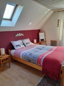 1 dormitorio con 1 cama grande y pared roja en Les Pensées, en Braine-lʼAlleud