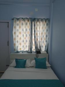 Postel nebo postele na pokoji v ubytování Sai Inn Mysore