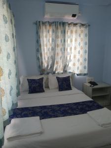 Postel nebo postele na pokoji v ubytování Sai Inn Mysore