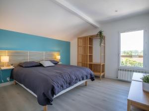 ein Schlafzimmer mit einem Bett und einer blauen Wand in der Unterkunft Holiday Home Chuchunieko by Interhome in Bidart