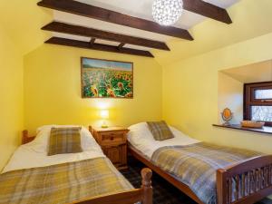 two beds in a room with yellow walls at Holiday Home Deveron Valley Cottages by Interhome in Marnoch