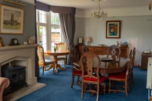 a dining room with a table and chairs and a fireplace at The Old Rectory Chicklade in Chicklade