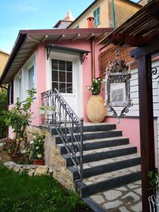 una casa rosa con escaleras delante en Florinda Lemon's Suite, en Cervo