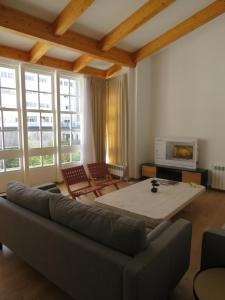 ein Wohnzimmer mit einem Sofa und einem Tisch in der Unterkunft APARTAMENTOS ARMANYA 3 in Lugo