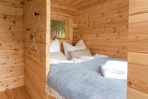 Habitación con cama en una cabaña de madera en Das Wiesenhaus: Wohnen im Tiny House direkt am Rhein en Colonia
