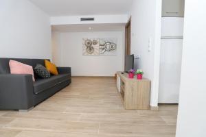 een woonkamer met een zwarte bank en een tafel bij APARTAMENTS AGNETA - Rem in Cambrils