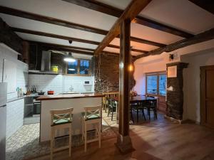 a kitchen with a table and a dining room at Casa Osu Pardo VuT in Caboalles de Abajo