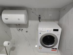 a washing machine in a bathroom with a toilet at Blue Apartment Riverside in Podgorica