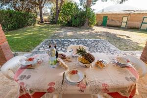 アルゲーロにあるAffittaSardegna-CASA LA VIGNAのテーブル(上に食べ物と飲み物付)