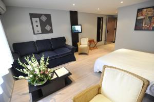 a living room with a couch and a bed at Logis Cottage Hotel in Vandoeuvre-lès-Nancy