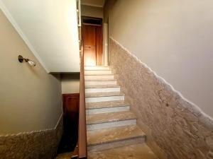 uma escada com uma escada que leva até uma porta em Casa Malù em Fiumicino