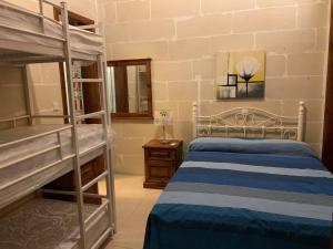 sypialnia z 2 łóżkami piętrowymi i lampką w obiekcie Qronfli Holiday Apartments With Swimming Pool w mieście San Lawrenz