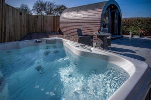 a hot tub in a backyard with a sauna at Bracken Burrows - 1 Bedroom Pod - New Hedges in New Hedges