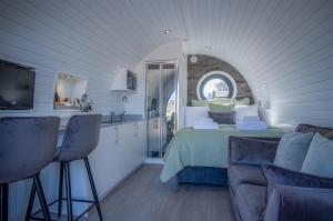 a kitchen and a bedroom with a bed and a couch at Bracken Burrows - 1 Bedroom Pod - New Hedges in New Hedges