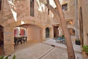 einen Innenhof eines Gebäudes mit einem Tisch und Stühlen in der Unterkunft Casa Alcariot 252 by Mallorca Charme in Artá
